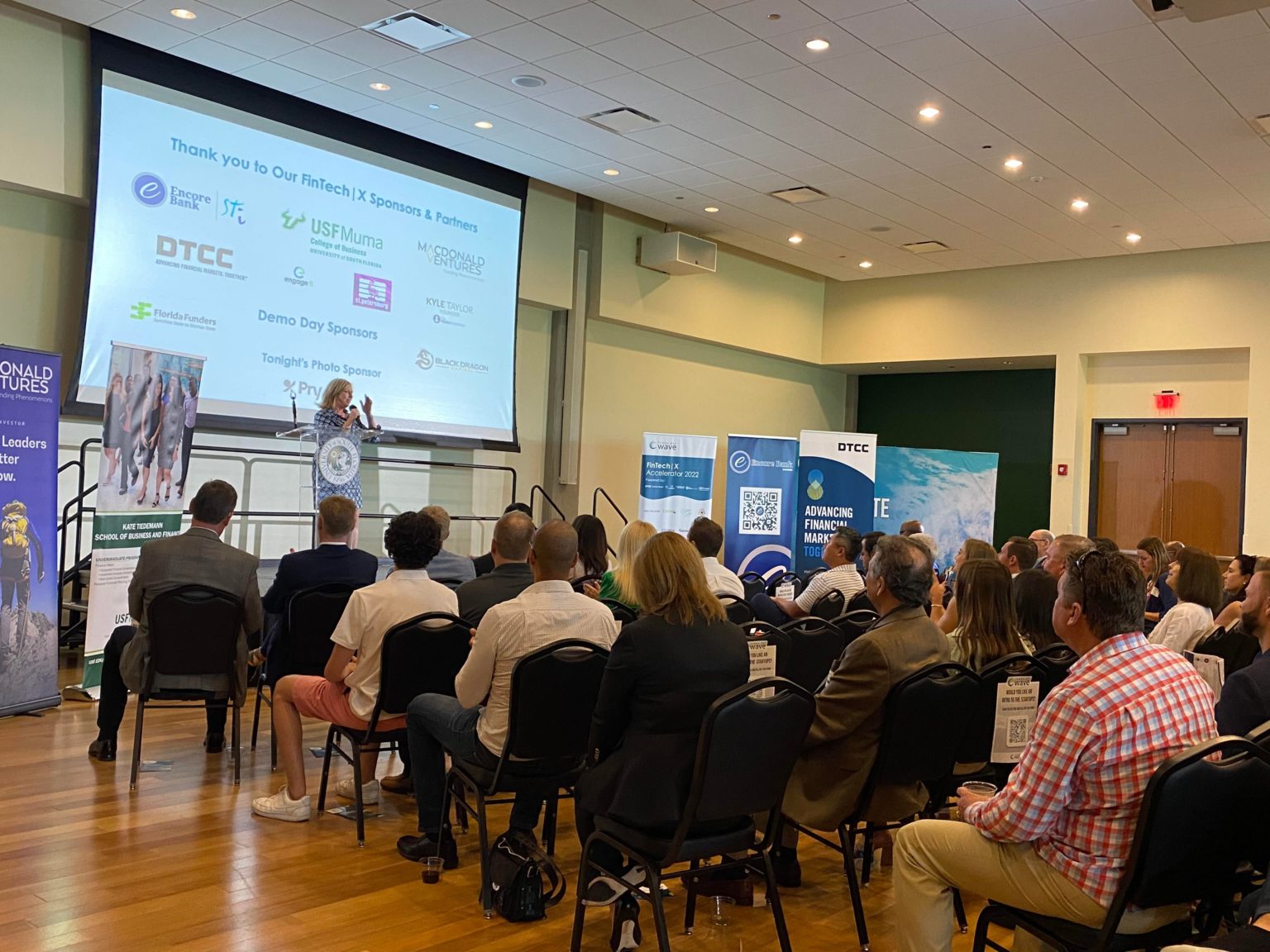 Tampa Bay Wave founder Linda Olson welcomes the attendees at the fintech accelerator program pitch night event in St. Petersburg. Photo by Veronica Brezina.